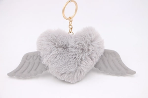 Detailed view of grey plush heart keychain with wings and a golden metal ring