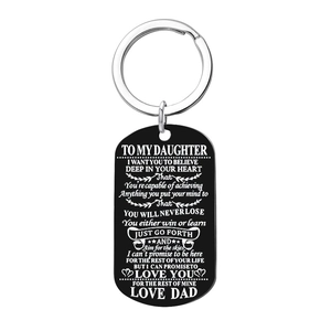 Detail of black metal dog tag keychain with white laser engraved message for daughter