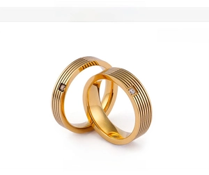 Macro detail of 4mm and 6mm gold titanium rings with striped texture and square zircon