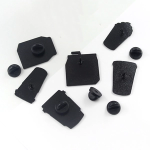 Detail view of the black metal enamel pin backs with secure rubber clutches on white base