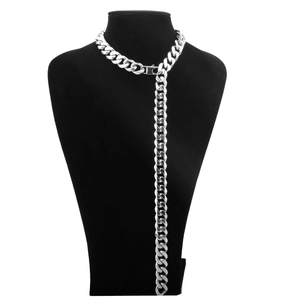Detailed view of silver Cuban link chain belt draped on black velvet mannequin