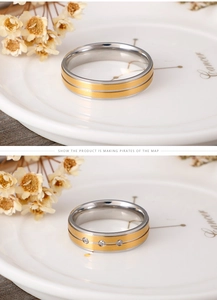 Detail view of two-tone frosted couple rings with three inlaid zircon stones on wood base