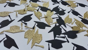 Close-up of black and gold glitter graduation cap confetti for party table decoration