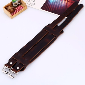 Detail view of dark brown punk leather wristband with double buckles and metal eyelets