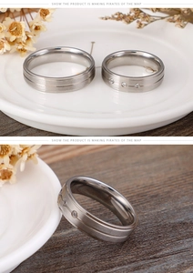 Detail of matte titanium steel couple rings with brushed finish and small inlaid gems