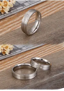 Detail of silver brushed finish ring with three small diamonds on a wood background