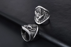 Détails de bagues aigle vintage en argent avec relief sur fond de cuir noir texturé