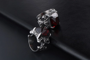 Macro view of vintage silver gothic rings featuring inlaid square red gemstones on leather