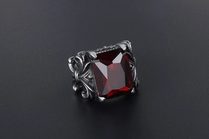 Macro detail of vintage floral titanium steel ring with a deep red rectangle gemstone