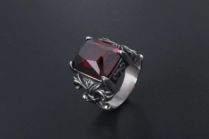 Close-up of a square-cut ruby on a gothic stainless steel ring with fleur-de-lis patterns