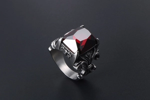 Macro shot of vintage titanium steel ring with rectangular red gemstone and floral relief