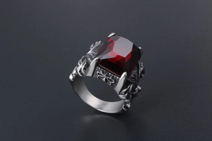 Macro detail of men's titanium steel ring with a square red gemstone and gothic relief