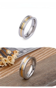 Detail of two-tone stainless steel ring with center gold inlay and small sparkling diamond