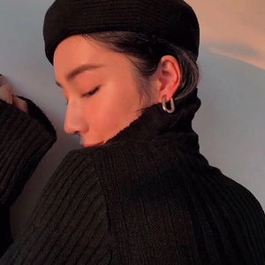 Boucles d'oreilles créoles minimalistes dorées en forme de U portées par un mannequin