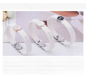 Detail of stainless steel silicone bracelet with hexagonal charms in gold, silver and black