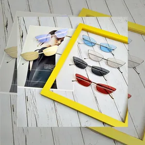 Macro shot of stylish rimless cat eye sunglasses in various colors on white wood