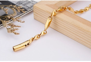 Macro detail of golden geometric rhombus and teardrop links with cylindrical clasp