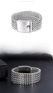 Detail of silver woven stainless steel bracelet with a secure press square clasp
