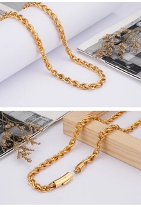 Detail of gold double-strand twisted chain with push-button clasp on white surface