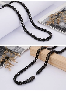 Close-up of black double-link chain necklace featuring a cylindrical magnetic clasp