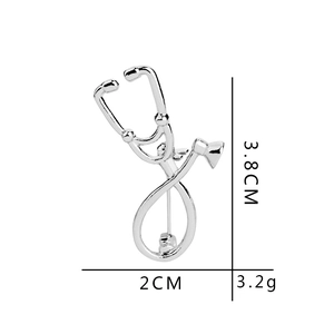 Detailed view of silver stethoscope brooch with size dimensions 3.8cm height and 2cm width