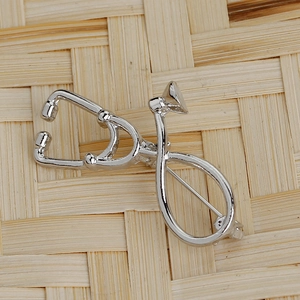 Detail of silver stethoscope brooch back showing a secure metal safety pin closure