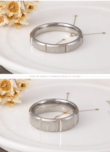 Detailed close-up of a brushed stainless steel ring with vertical grooved textures