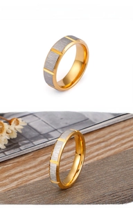 Macro shot of two-tone stainless steel ring featuring brushed silver and gold inner band