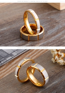 Macro shot of two-tone stainless steel couple rings with brushed finish and gold edges