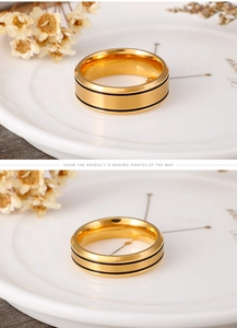 Detail of gold stainless steel ring featuring brushed surface and dual black lines