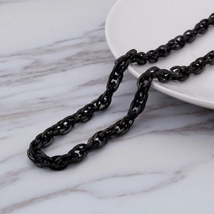 Polished black stainless steel interlocking chain necklace on white marble background