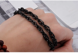 Close-up of black stainless steel double-interlocking flat chain bracelet on wrist