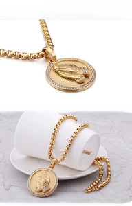 Gros plan du collier HIPHOP doré avec pendentif mains en prière et bordure en zircone cubique