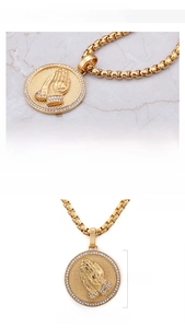 Gros plan du pendentif mains en prière plaqué or 18K avec zircons et chaîne cubique