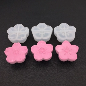 Macro detail of 3D cherry blossom silicone molds with pink resin flower samples