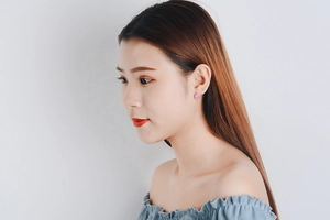 Detailed view of small purple zircon stud earrings on a female model with Korean style