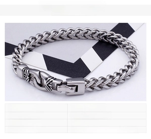Macro shot of men's stainless steel wheat chain bracelet with a detailed textured clasp