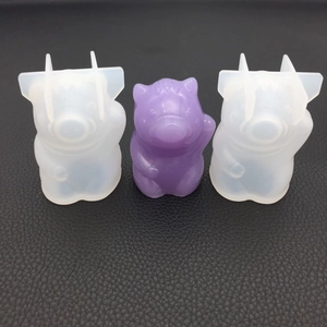 3D pig silicone molds and purple resin finished product on a black textured surface
