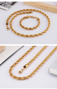 Detail of gold-tone twisted rope chain necklace and bracelet set on a white background