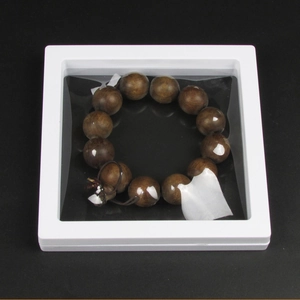 Brown wooden bead bracelet displayed in a white PE film 3D floating frame box