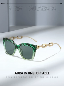 Detailed view of green tortoiseshell sunglasses with bold gold metal chain temples