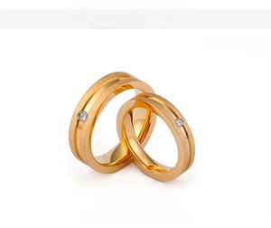Detail of 18K gold plated couple rings with brushed finish and inset cubic zirconia