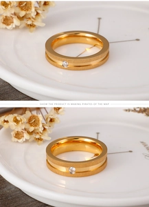Macro detail of gold plated stainless steel couple ring with matte finish and single crystal