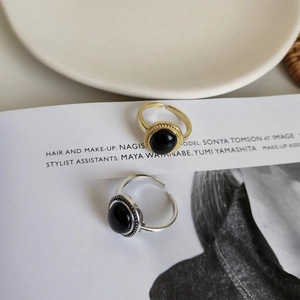 Detailed close-up of S925 sterling silver rings with oval black onyx and gold finish