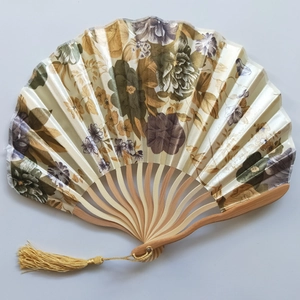 Detailed view of Japanese style silk folding fan with floral patterns and golden tassel