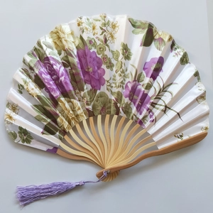 Detail of bamboo fan ribs with floral silk fabric and a purple silk tassel pendant