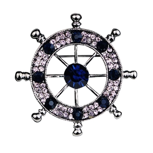 Silver nautical helm brooch featuring navy blue and pink crystals on white backdrop