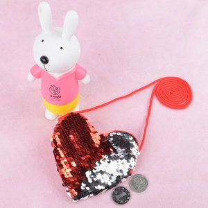 Detail of heart-shaped crossbody bag with red and silver reversible sequins and strap