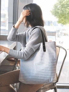 Canvas tote bag with blue gingham pattern, black leather handles and rivet details
