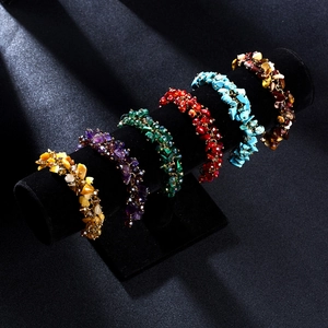 Detail view of six bohemian stone bead bracelets displayed on a black velvet stand